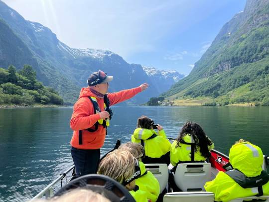 Cruise boat gliding through Norway fjords near Flåm